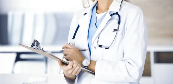 Mujer médica desconocida en el trabajo en la clínica. Médico femenino controla historial de medicación y resultados del examen médico, primer plano. Concepto de medicina — Foto de Stock