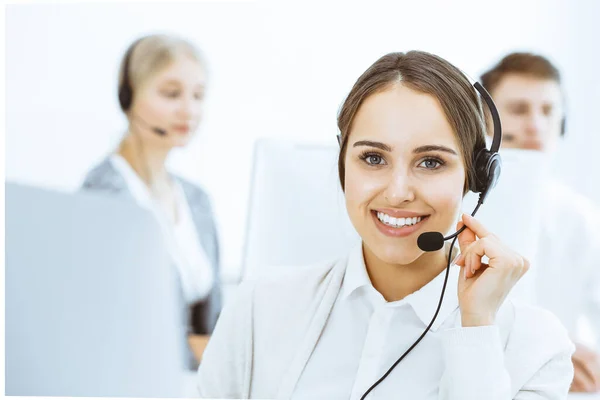 Call center. Gruppe verschiedener Akteure bei der Arbeit. Schöne Frau im Headset, die mit Kunden des Telemarketing-Dienstes kommuniziert. Geschäftskonzept — Stockfoto