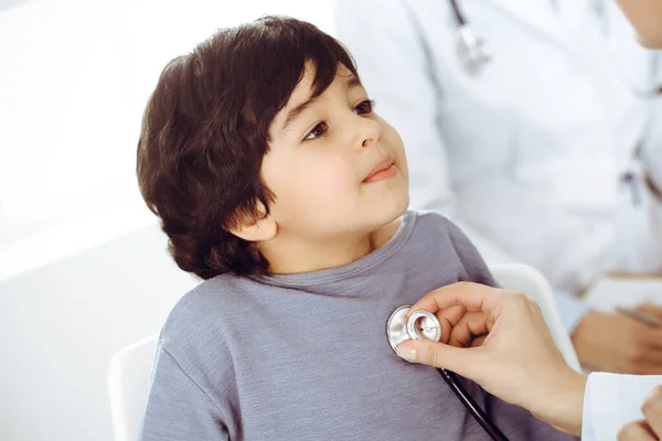 Docteur-femme examinant un enfant patient par stéthoscope. Joli garçon arabe sur rendez-vous chez le médecin. Concept de médecine — Photo