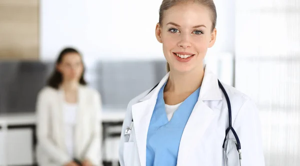 Mujer - médico de pie en la clínica. Médico en el trabajo, retrato de estudio. Concepto de medicina y salud — Foto de Stock