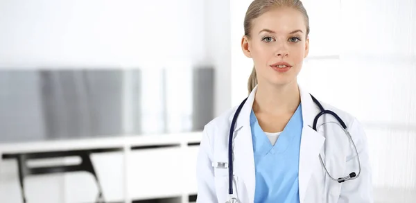 Mujer - doctora sentada en la clínica. Médico en el trabajo, retrato de estudio. Concepto de medicina y salud —  Fotos de Stock