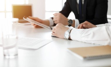 Bilinmeyen iş adamları güneşli ofiste tablet bilgisayar kullanıyorlar. İş adamı, meslektaşı ile birlikte çalışıyor, yakın plan.