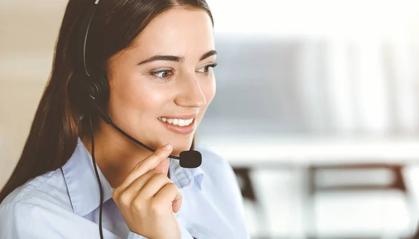 Brunette representante do serviço ao cliente feminino usando headset e clientes de consultoria on-line. Centro de atendimento — Fotografia de Stock