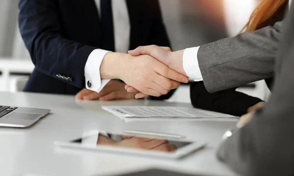 Onbekende zakenman schudt handen met zijn collega of partner boven het bureau in zonnig kantoor, close-up — Stockfoto