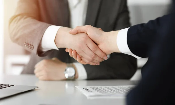 Empresário desconhecido apertando as mãos com seu colega ou parceiro acima da mesa no escritório ensolarado, close-up — Fotografia de Stock