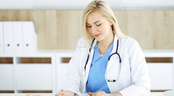 Kvinna-läkare som står på sjukhus eller klinik och använder tablettdator. Data och bästa service inom medicin och sjukvård — Stockfoto