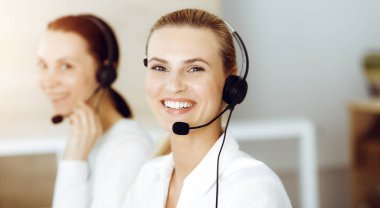 Sarışın bayan müşteri hizmetleri temsilcisi müşterilerine danışmanlık yapıyor. Çağrı merkezi kavramı