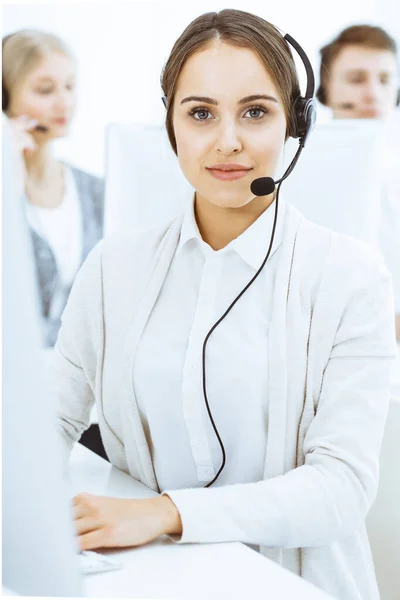 Call center. Group of diverse operators at work. Beautiful woman in headset communicating with customers of telemarketing service. Business concept — Stock Photo, Image
