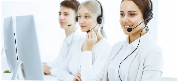 Centro de llamadas. Grupo de operadores diversos en el trabajo. Hermosa mujer en auriculares comunicándose con los clientes del servicio de telemarketing. Concepto empresarial — Foto de Stock
