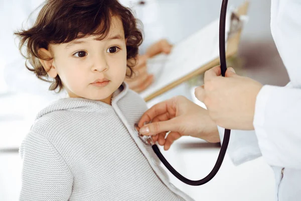 Mujer-médico examinando a un niño paciente por estetoscopio. Lindo niño árabe en la cita con el médico. Concepto de medicina — Foto de Stock