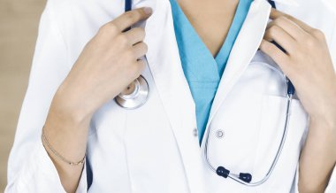 Klinikte steteskopla duran kimliği belirsiz kadın doktor, yakın plan. Tıp konsepti