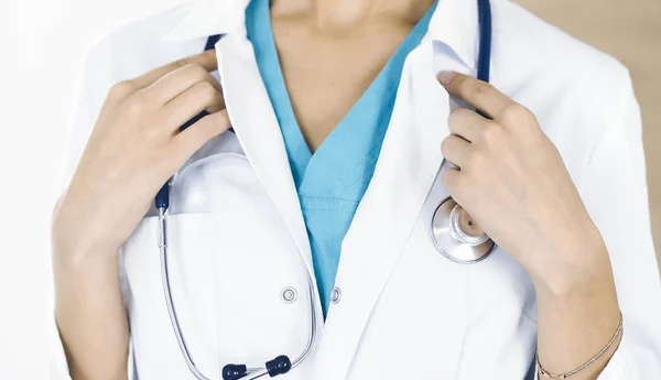 Nieznana lekarka stojąca ze stetoskopem w klinice, zbliżenie. Koncepcja medycyny — Zdjęcie stockowe