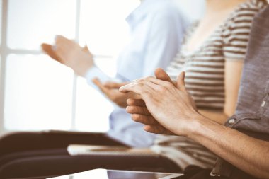 İş adamları toplantı ya da konferansta el çırpıyor. Modern beyaz ofisteki bir grup tanınmayan iş adamı ve kadın. Başarı takım çalışması, kurumsal koçluk ve alkış konsepti