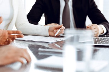 İş adamları modern ofiste birlikte çalışarak sözleşmeyi tartışıyor. Meslektaşları veya avukatları olan tanınmamış işadamı ve kadın görüşmede