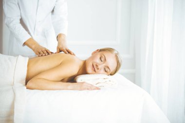 Güzel, mutlu bir kadın gözleri kapalı sırt masajından hoşlanıyor. Güzellik ve Spa salonu konsepti