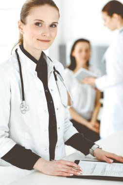 İş yerinde iş arkadaşı ve hastası olan kadın doktor. Hastane resepsiyonunda duran orta yaşlı kadın doktor tıbbi belgeleri dolduruyor ya da reçete yazıyor. Tıptaki veriler