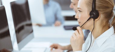 Merkezi ara. İş yerinde sıradan giyinmiş bir grup operatör. Müşteri hizmetleri ofisinde kulaklık takan sarışın bir iş kadını. İş dünyasındaki haberleşmeler