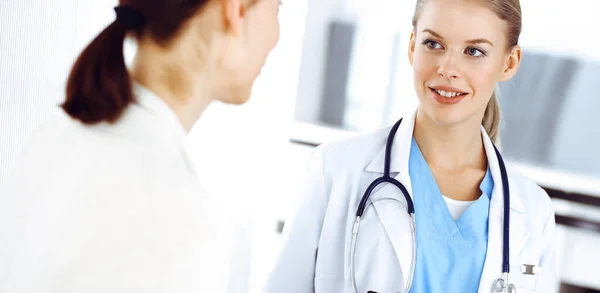 Woman - doctor consults her female patient in clinic. Medicine concept