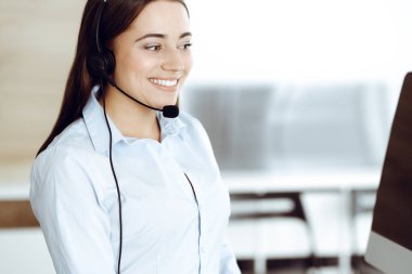 Esmer kadın müşteri hizmetleri temsilcisi internet üzerinden müşterilere danışıyor. Çağrı merkezi ve iş adamları kavramı