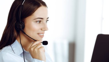 Esmer kadın müşteri hizmetleri temsilcisi internet üzerinden müşterilere danışıyor. Çağrı merkezi ve iş adamları kavramı