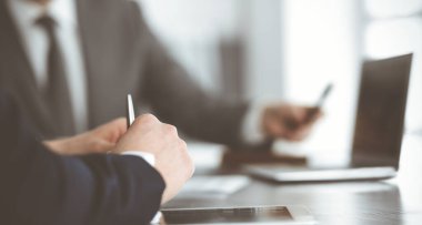 Bilinmeyen iş adamları modern ofisteki masada dizüstü bilgisayar kullanıyorlar. İş adamı ya da erkek girişimci meslektaşı ile birlikte çalışıyor. Takım çalışması ve ortaklık kavramı