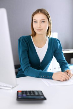 Muhasebeci mali durumu kontrol ediyor ya da vergi formları için hesap makinesi geliri ile sayıyor, eller yakın çekim. Ofisteki masada oturan ve çalışan bir iş kadını. Denetim kavramı