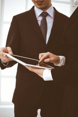 İşadamı ve kadın ofiste soruları tartışmak için tablet bilgisayar kullanıyorlar. Toplantının ortakları veya meslektaşları. İş birliği kavramı