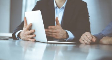 Modern ofiste birlikte çalışırken dizüstü bilgisayarı kullanan iş adamları. İş yerinde iş arkadaşı olan tanınmamış bir iş adamı ya da erkek girişimci. Takım çalışması ve ortaklık kavramı