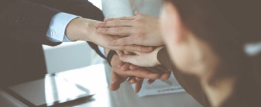 Takım çalışması yapan ve el ele tutuşan iş adamları grubu ya da modern ofiste beş kişi. Bilinmeyen işadamı ve kadınlar elleriyle daire çiziyorlar.