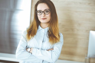 Modern ofisteki iş yerinde iş kadını vesikalığı. Bilinmeyen iş kadını tablet bilgisayarla ayakta duruyor. Genç muhasebeci ya da sekreter iyi görünüyor.