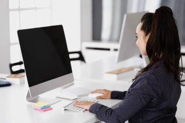 Modern ofisteki işyerinde bilgisayar kullanan bir iş kadını. Esmer sekreter ya da kadın avukat gülümsüyor ve mutlu görünüyor. Zevk ve başarı için çalışmak