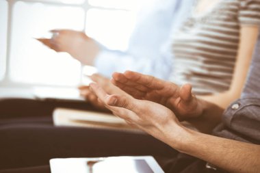 İş adamları toplantı ya da konferansta el çırpıyor. Modern beyaz ofisteki bir grup tanınmayan iş adamı ve kadın. Başarı takım çalışması, kurumsal koçluk ve alkış konsepti