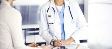 Bilinmeyen kadın doktor ve hasta hastanede. Sarışın doktor ilaç kayıtlarını ve sınav sonuçlarını kontrol ederken pano kullanıyor, yakın plan. Tıp konsepti