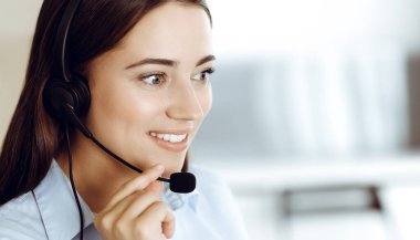 Esmer kadın müşteri hizmetleri temsilcisi internet üzerinden müşterilere danışıyor. Çağrı merkezi ve iş adamları kavramı