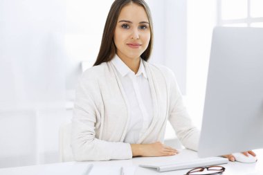 Beyaz ofisteki bilgisayarla çalışan bir iş kadını. Öğrenci kız ders çalışıyor ya da sekreter rapor yazıyor. Başarı konsepti