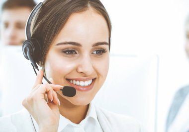 Merkezi ara. Çeşitli operatörler iş başında. Telepazarlama servisinin müşterileriyle iletişim kuran kulaklıklı güzel bir kadın. İş konsepti