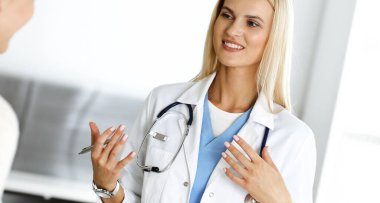 Hastanedeki kadın-doktor kadın hastayla seve seve iletişim kurar. Sarışın doktor tıbbi geçmişi ve muayene sonuçlarını kontrol ediyor. Tıp konsepti