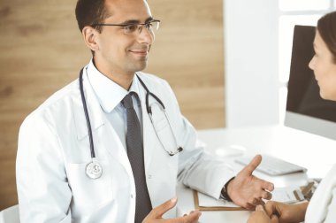 Doktor ve hasta klinikteki masada otururken bir şey tartışıyorlar. Tıp kavramı ve klinikte rahat hizmet