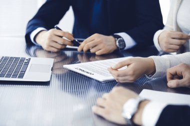 İş adamları modern ofiste birlikte çalışarak sözleşmeyi tartışıyor. Meslektaşları veya avukatları olan tanınmamış işadamı ve kadın görüşmede