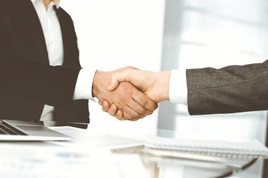 Bilinmeyen çeşitli iş adamları ofis masasındaki toplantıyı bitirmek için el sıkışıyorlar, yakın plan. El sıkışma kavramı