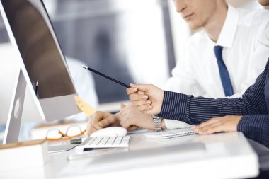 İş kadını ve erkek, modern ofiste bilgisayar ve bloknot kullanarak soruları tartışıyorlar. Yakın plan. İş dünyasında takım çalışması