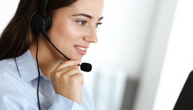 Esmer kadın müşteri hizmetleri temsilcisi internet üzerinden müşterilere danışıyor. Çağrı merkezi ve iş adamları kavramı