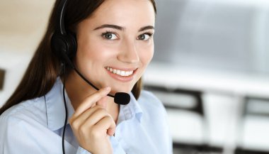 Esmer kadın müşteri hizmetleri temsilcisi internet üzerinden müşterilere danışıyor. Çağrı merkezi ve iş adamları kavramı