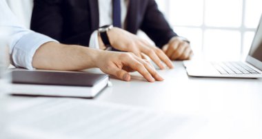 Bilinmeyen iş adamları modern ofisteki masada dizüstü bilgisayar kullanıyorlar. İş adamı ya da erkek girişimci meslektaşı ile birlikte çalışıyor. Takım çalışması ve ortaklık kavramı