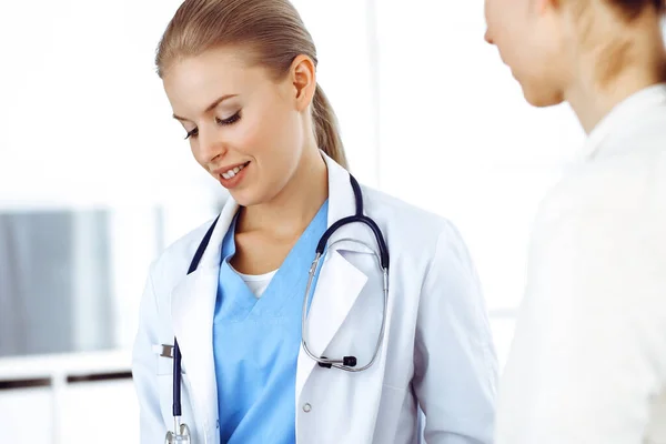 Woman - doctor consults her female patient while using clipboard and medication history record. Medicine concept