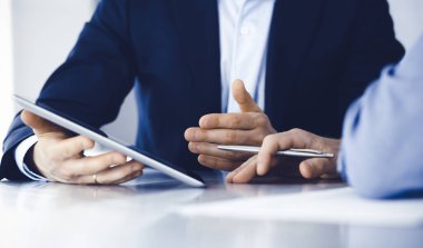 Modern ofiste birlikte çalışırken iş adamları tablet bilgisayar kullanıyorlar. İş yerinde iş arkadaşı olan tanınmamış bir iş adamı ya da erkek girişimci. Takım çalışması ve ortaklık kavramı