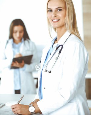 Doktor kadın ilaç kayıtlarını ve sınav sonuçlarını pano kullanarak kontrol ediyor. Tıp ve sağlık hizmetleri kavramı