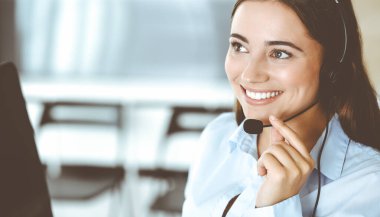 Esmer kadın müşteri hizmetleri temsilcisi internet üzerinden müşterilere danışıyor. Çağrı merkezi ve iş adamları kavramı