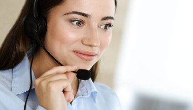 Esmer kadın müşteri hizmetleri temsilcisi internet üzerinden müşterilere danışıyor. Çağrı merkezi ve iş adamları kavramı