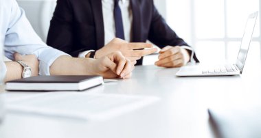 Bilinmeyen iş adamları modern ofisteki masada dizüstü bilgisayar kullanıyorlar. İş adamı ya da erkek girişimci meslektaşı ile birlikte çalışıyor. Takım çalışması ve ortaklık kavramı